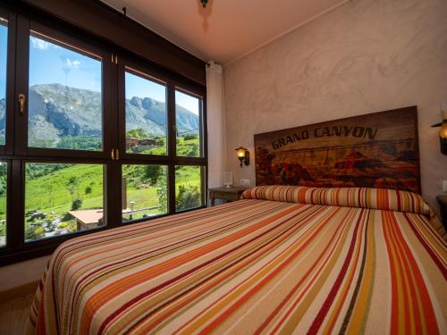 a bedroom with a large bed with a large window at La Posta del Camín Real in La Plaza