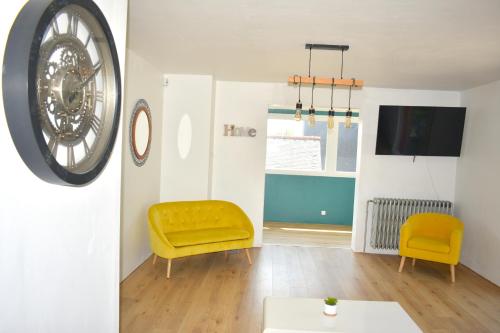 salon z żółtym krzesłem i telewizorem w obiekcie À 2mn de la plage, maison avec grand terrain clos w mieście Plérin