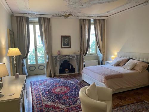 a bedroom with a bed and a chair and a fireplace at Relais Dei Mandorli suite centro in Bergamo