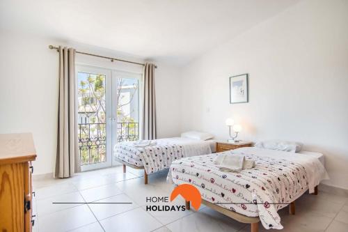 a bedroom with two beds and a window at #088 T2 São Rafael 64B by Home Holidays in Albufeira
