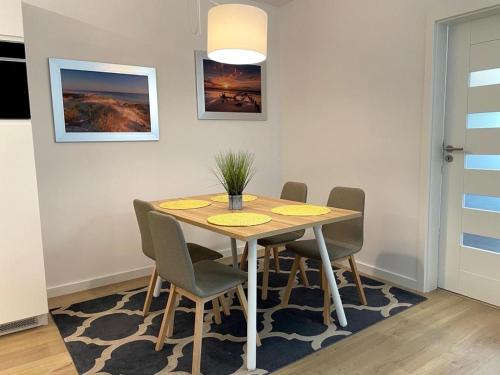 uma sala de jantar com mesa e cadeiras em Klif Apartamenty Nadmorskie Tarasy em Colberga