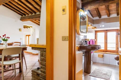 a kitchen and dining room with a sink and a table at Mansarda Roccatederighi in Roccatederighi