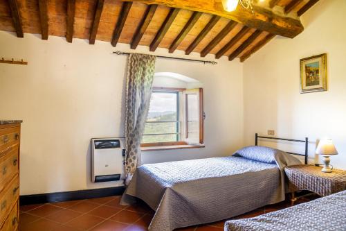 a bedroom with two beds and a window at Mansarda Roccatederighi in Roccatederighi