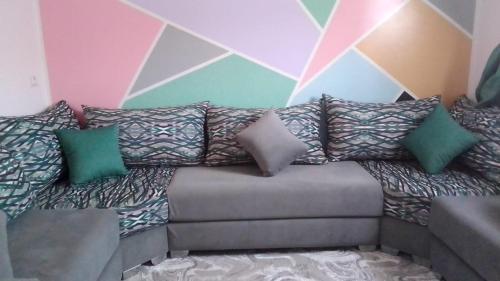 a couch with pillows on it in a room at appartement pour famille in Agadir
