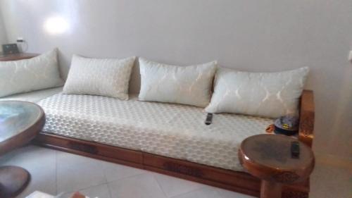 a couch with white pillows in a room at appartement pour famille in Agadir