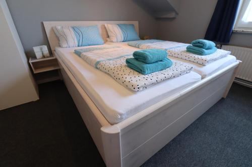 a large bed with two blue towels on it at Ostsee Pension Pohnsdorfer Mühle in Sierksdorf