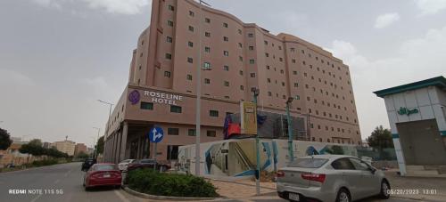فندق روزلاين في الرياض: مبنى كبير فيه سيارات تقف امامه