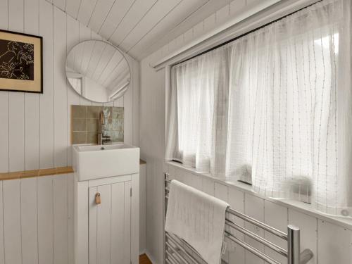 a white bathroom with a sink and a window at Pass the Keys Stunning Open Plan Home in City in Canterbury