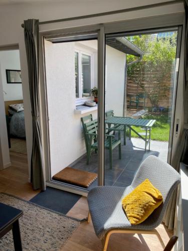 une porte coulissante en verre menant à une terrasse. dans l'établissement Maison cosy rénovée avec jardin, à Rouen