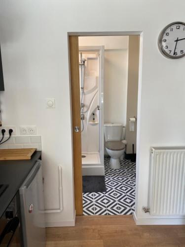 La salle de bains est pourvue de toilettes et d'une horloge murale. dans l'établissement Maison cosy rénovée avec jardin, à Rouen