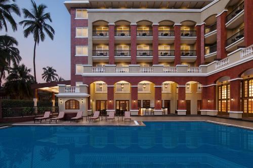 un hotel con piscina frente a un edificio en Fairfield by Marriott Goa Calangute, en Calangute