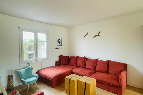 een woonkamer met een rode bank en een blauwe stoel bij Spacious house with garden in La Rochelle