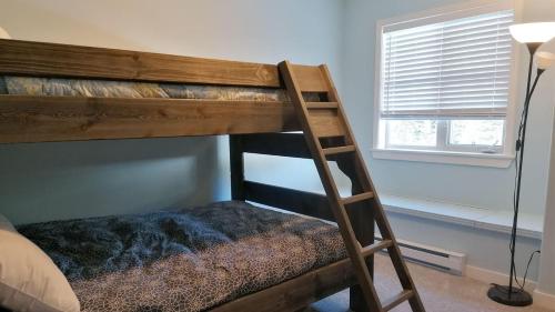 a bunk bed with a ladder in a room at Crystal Forest #29 by Bear Country in Sun Peaks