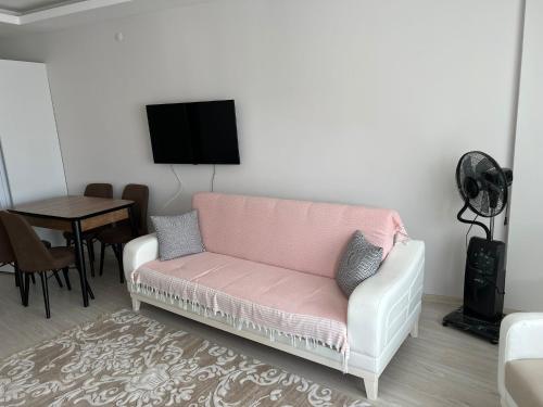 a living room with a pink couch and a table at Balkonlu Lüks Eşyalı Aile Evi in Sinop
