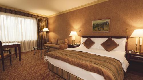 a hotel room with a large bed and a desk at InterContinental Almaty, an IHG Hotel in Almaty