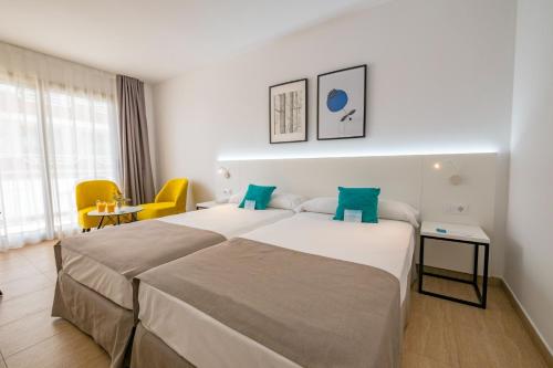 Habitación de hotel con 2 camas y mesa en DWO Sirius - Adults Only, en Santa Susanna