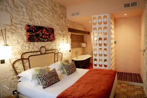 1 dormitorio con 1 cama y baño con bañera en Le petit hotel, en Saint-Rémy-de-Provence
