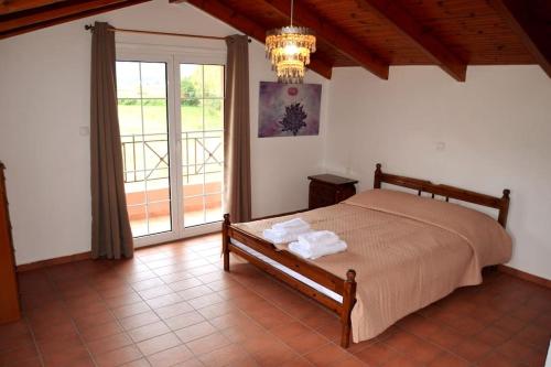 a bedroom with a bed and a large window at Seaside Villa in Káto Vasilikí