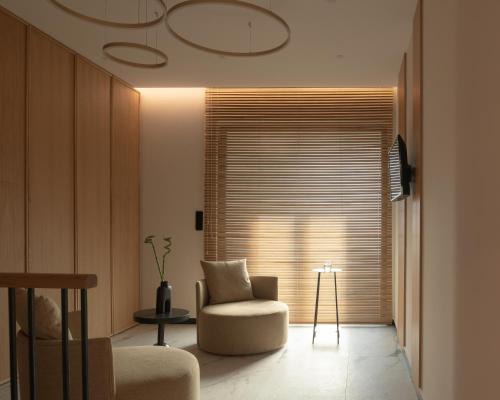 a living room with a chair and a window at Villa En Paraiso a Majestic SeaView Retreat By ThinkVilla in Giannoudi