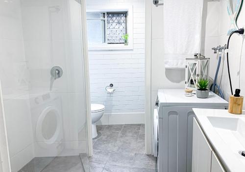 uma casa de banho branca com um WC e um lavatório em Cooly Coastal Escape walk to beach & shops em Gold Coast