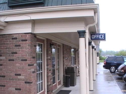 a brick building with a sign that reads office at Hometown Inn Galion in Galion