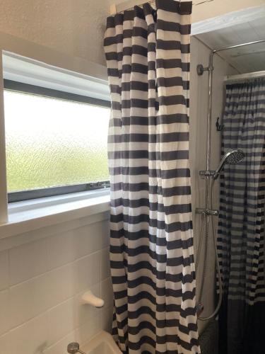 a bathroom with a black and white shower curtain at Bjørnø Vingård B&B - bed&bath in Bjørnø By