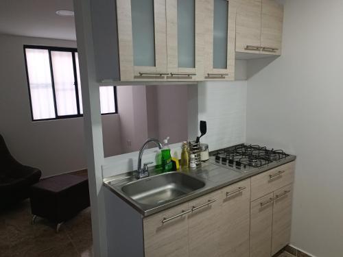uma cozinha com um lavatório e um fogão em Apto 202 em Cúcuta