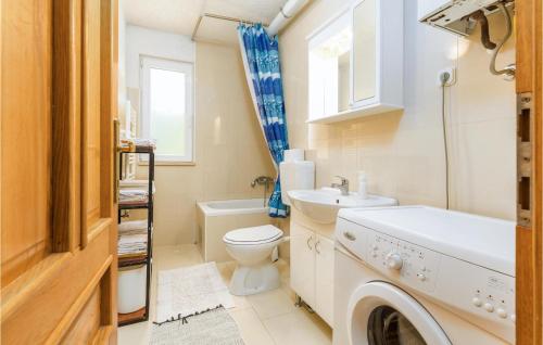 a bathroom with a toilet sink and a washing machine at Amazing Apartment In Medulin With 2 Bedrooms And Wifi in Medulin