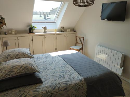 een slaapkamer met een bed, een tv en een raam bij Le Clos des Mouettes in Calais