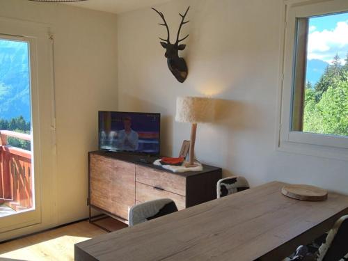 d'une salle à manger avec une table, une télévision et une fenêtre. dans l'établissement Studio confortable 4 pers, proche pistes, centre et commerces - FR-1-733-56, à Crest-Voland