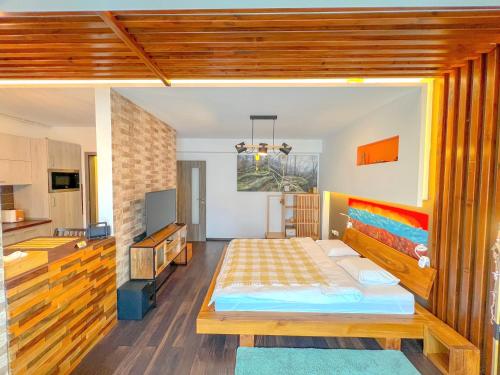a bedroom with a large bed and a kitchen at Wooden Touch Studio in Braşov