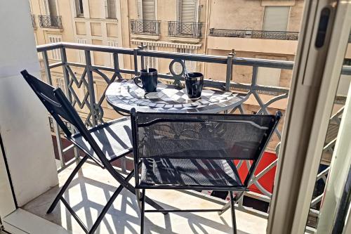 d'une table et d'une chaise sur un balcon avec deux tasses. dans l'établissement HENRI CAMILLE REAL ESTATE- Miramar - one bedroom apt - Croisette sea view, à Cannes