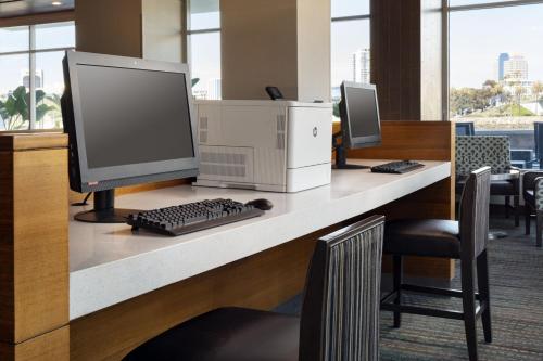 a desk with a computer and a keyboard and monitor at Residence Inn Long Beach Downtown in Long Beach