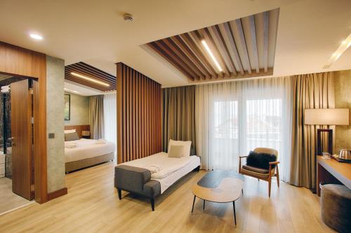 a hotel room with a bed and a couch and a table at Kazdağları Allia Thermal Health & Spa in Edremit