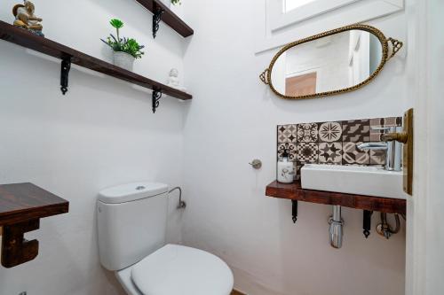 a bathroom with a toilet and a sink and a mirror at Casa forn magí in Mora la Nueva