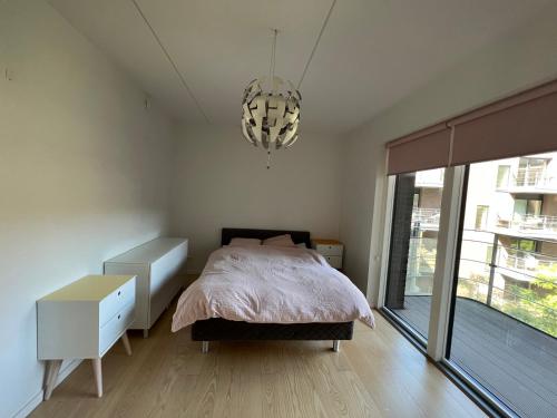 a bedroom with a bed and a chandelier at Copenhagen centre luxury apartment - Østerbro in Copenhagen