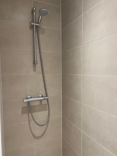 a shower with a shower head in a bathroom at Copenhagen centre luxury apartment - Østerbro in Copenhagen