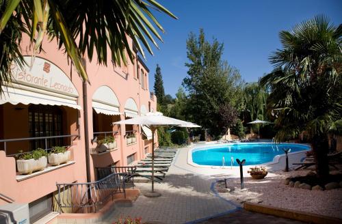 a resort with a swimming pool and a building at Hotel Villa Leri in Monte Colombo