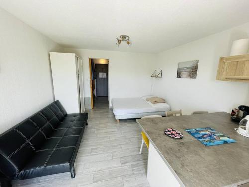 un salon avec un canapé et un lit dans l'établissement Studio rénové, calme, proche plage et commodités, parking inclus - FR-1-723-105, au Cap d'Agde
