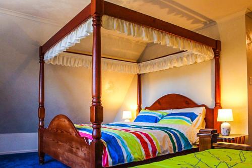 a bedroom with a large bed with a canopy at The Manor in Blue Mountains in Wentworth Falls