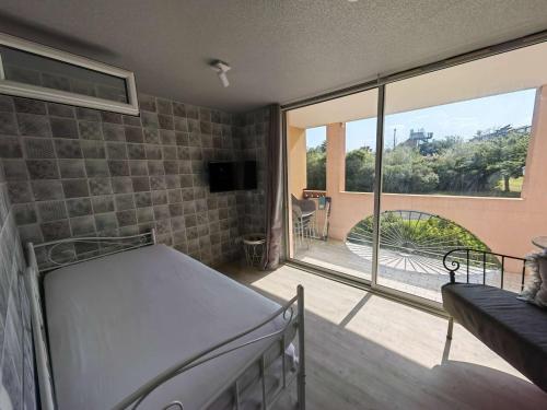 une chambre avec un lit et une grande fenêtre dans l'établissement Studio rénové, terrasse, piscine, proche plage et loisirs, parking, Wi-Fi, équipements bébé inclus - FR-1-607-165, au Cap d'Agde