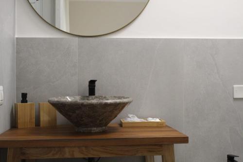 La salle de bains est pourvue d'un lavabo en pierre et d'un miroir. dans l'établissement Camera di Luna Prime, à San Cesario di Lecce