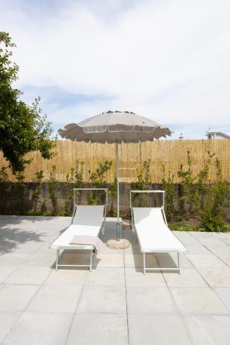 two chairs and an umbrella on a patio at Residence O'Sole Mio Pompei in Pompei