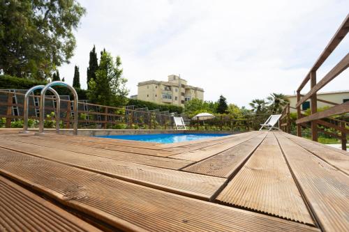 a wooden deck next to a swimming pool at Residence O'Sole Mio Pompei in Pompei