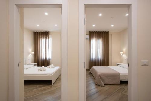 a hotel room with two beds and a mirror at Residence O'Sole Mio Pompei in Pompei