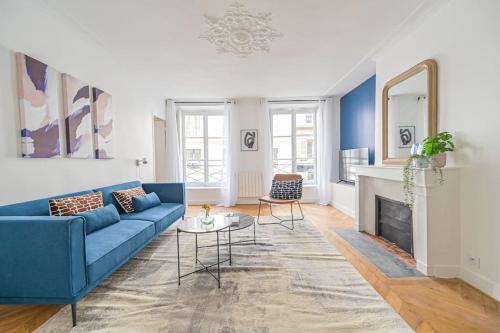 un salon avec un canapé bleu et une cheminée dans l'établissement Appart 4pers#2 Bedrooms#Louvres#Palais Royal#Opéra, à Paris