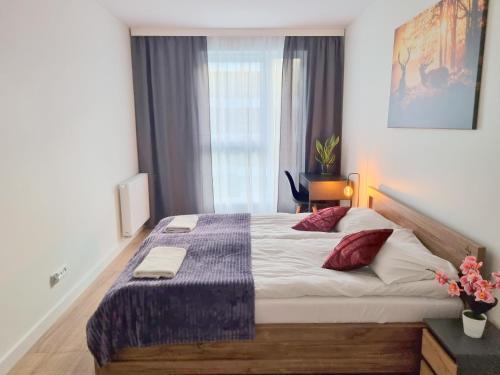 a bedroom with a large bed and a window at Apartment with 2 Bedrooms & Parking Wrocław by Renters in Wrocław