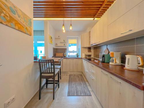 a large kitchen with a table and a chair in it at Wooden Touch Studio in Braşov