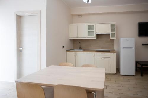a white kitchen with a white table and chairs at Residence O'Sole Mio Pompei in Pompei