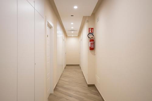 a hallway with white walls and wood floors and a fire hydrant at Residence O'Sole Mio Pompei in Pompei